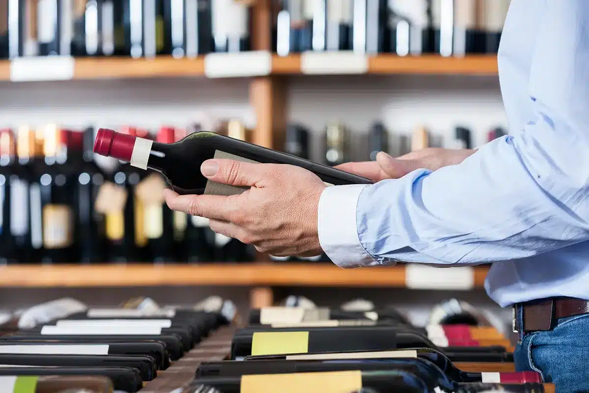 person-holding-bottle-of-wine person holding bottle of wine