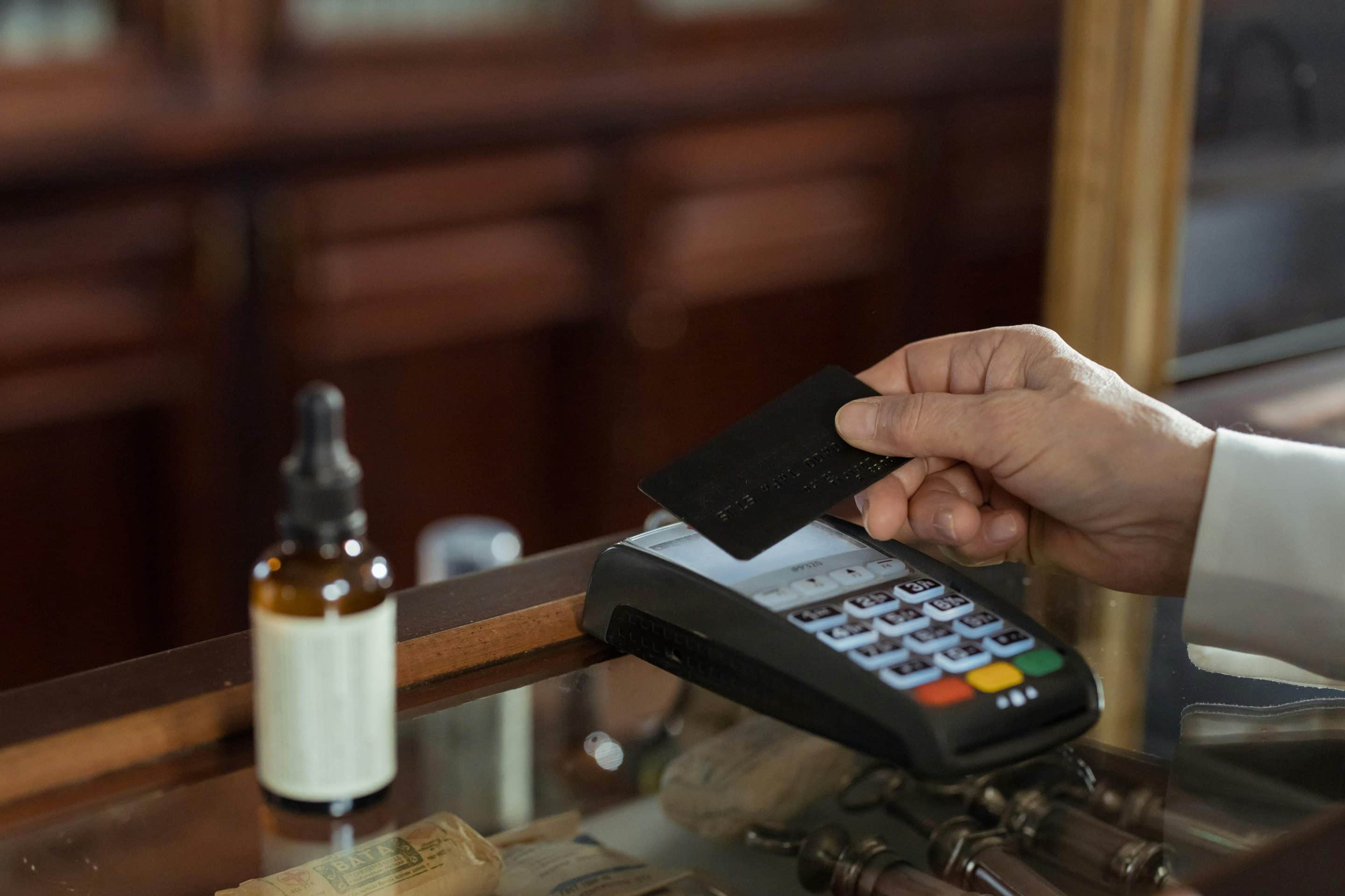 hand-holding-credit-card-near-payment-portal hand holding credit card near payment portal